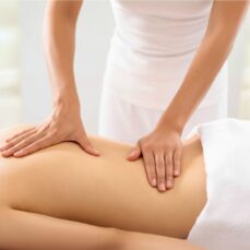 Persona recibiendo un masaje descontracturante en casa sobre camilla profesional